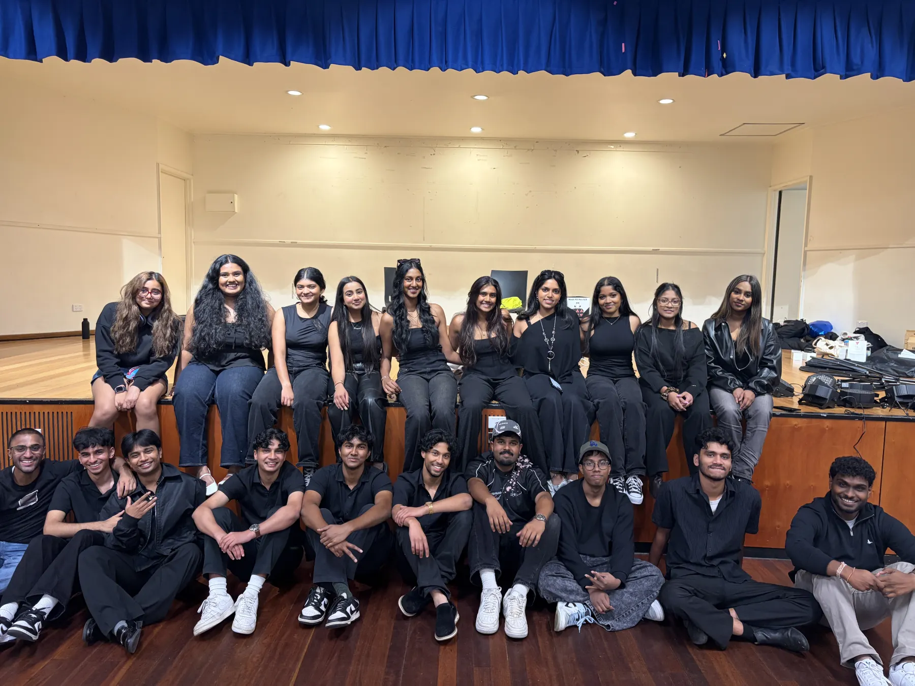 Members dressed in black on stage after a performance night.