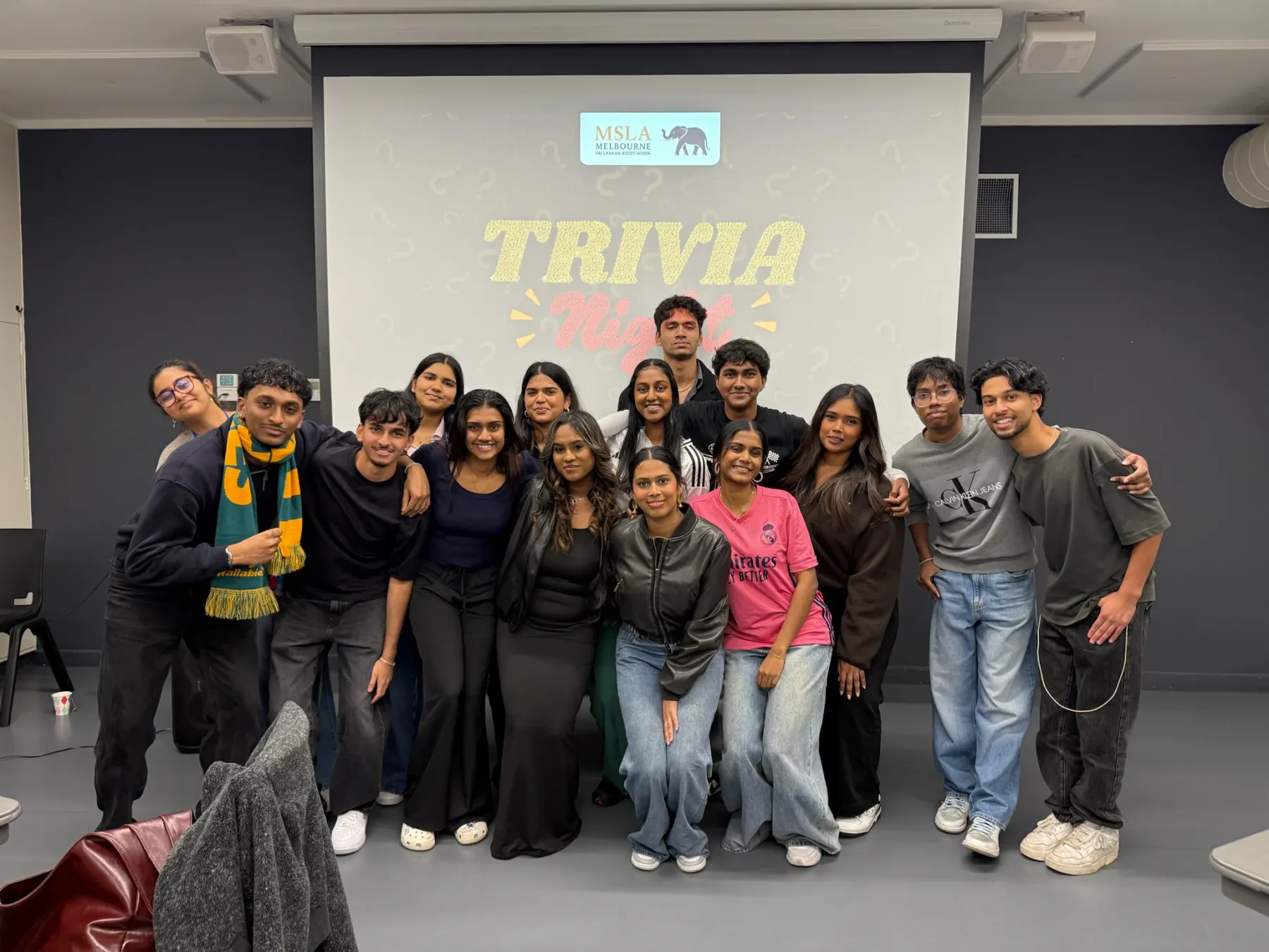 Members at MSLA Trivia Night, in front of the event screen.